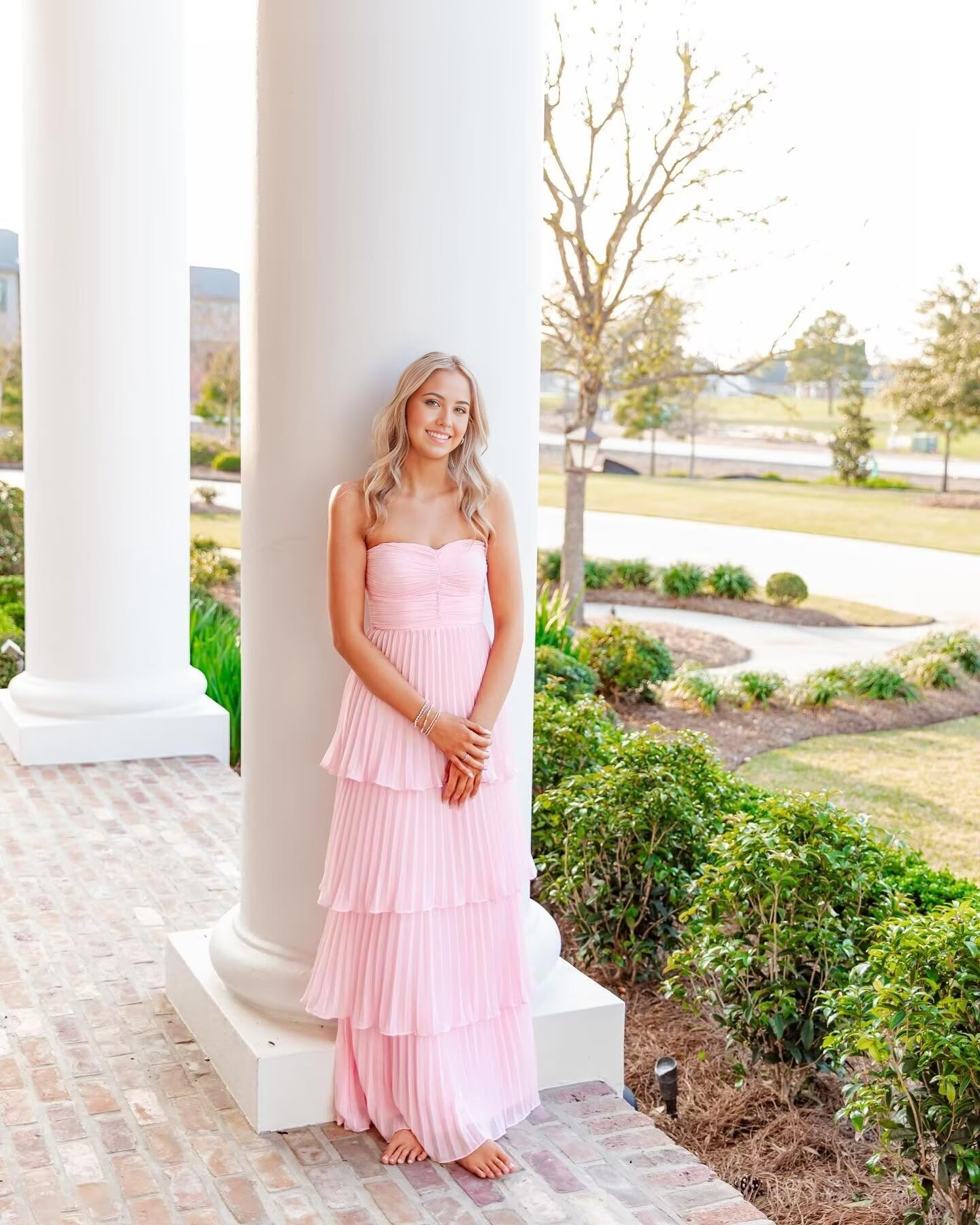 Model wearing an elegant A-line strapless ruffle tiered chiffon formal dress.