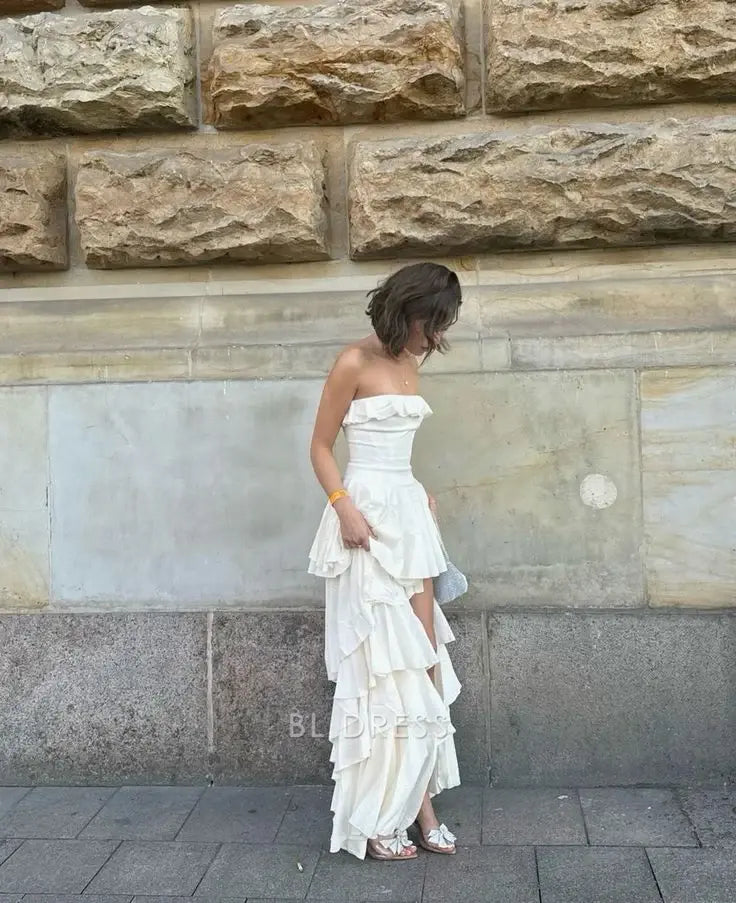 Woman wearing an elegant A-line strapless satin formal dress with a slit.