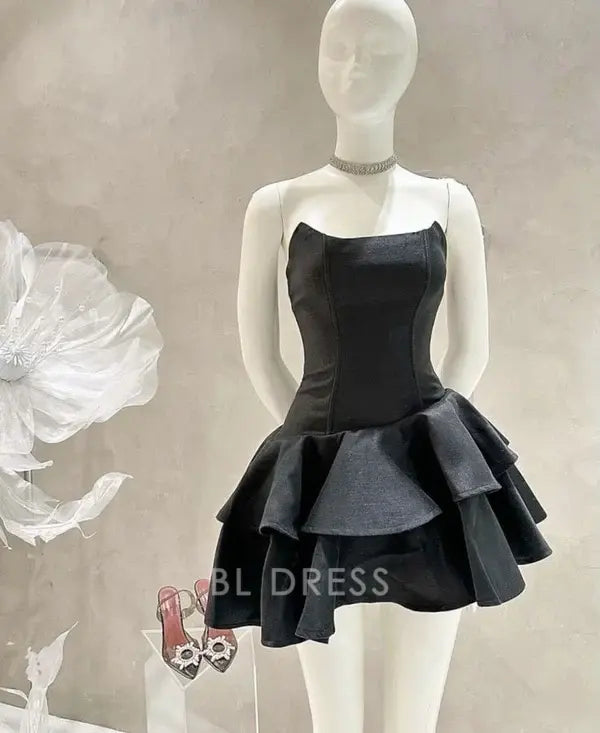 Model wearing an elegant black strapless A-line short dress.