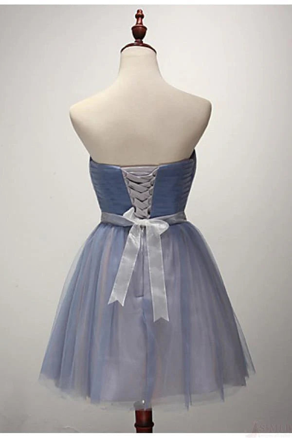 Model wearing a short A-line strapless cocktail party dress.