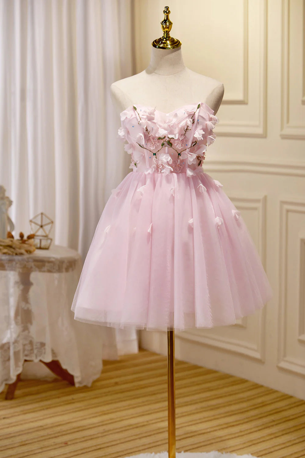 Model wearing an elegant A-line strapless short tulle homecoming dress.