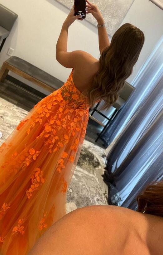 Side view of the orange A-line formal dress with intricate lace detailing.