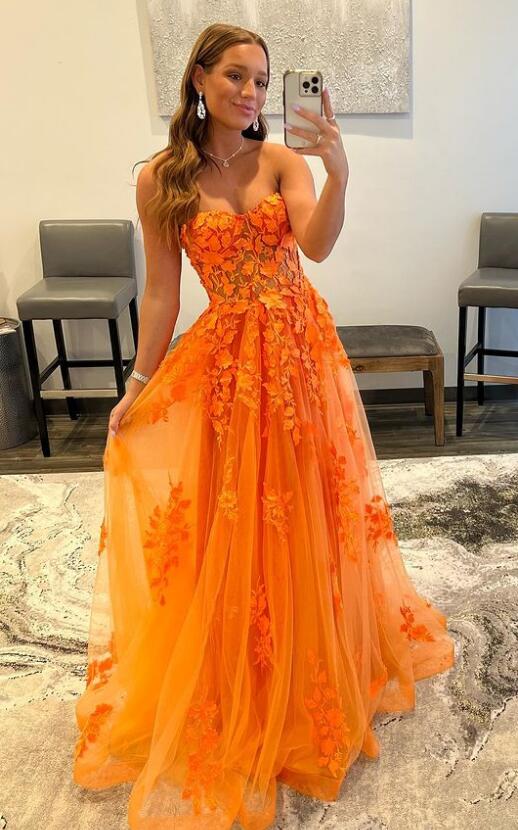 Back view of the long orange A-line sweetheart lace gown.