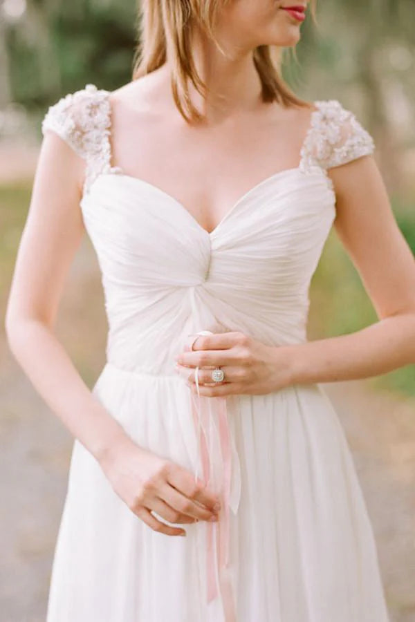 Detail of sweetheart neckline and cap sleeves on a chiffon wedding dress.