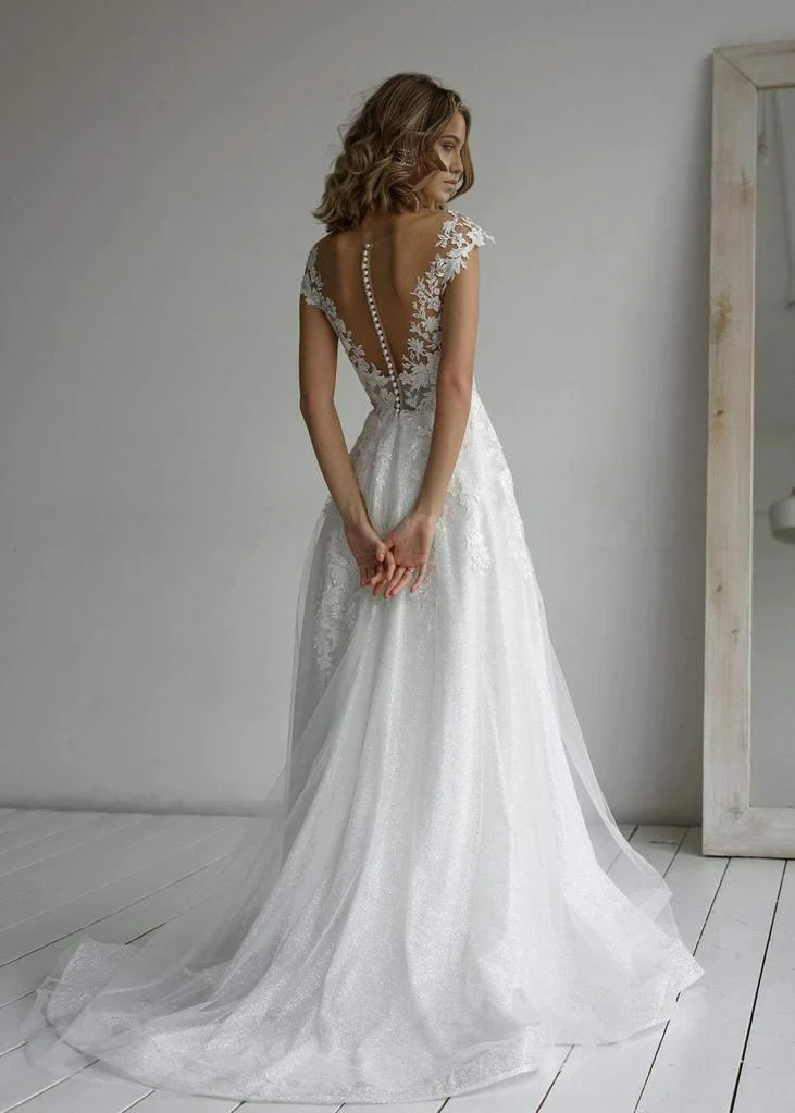 Full view of a bride wearing an elegant A-line glitter wedding gown.