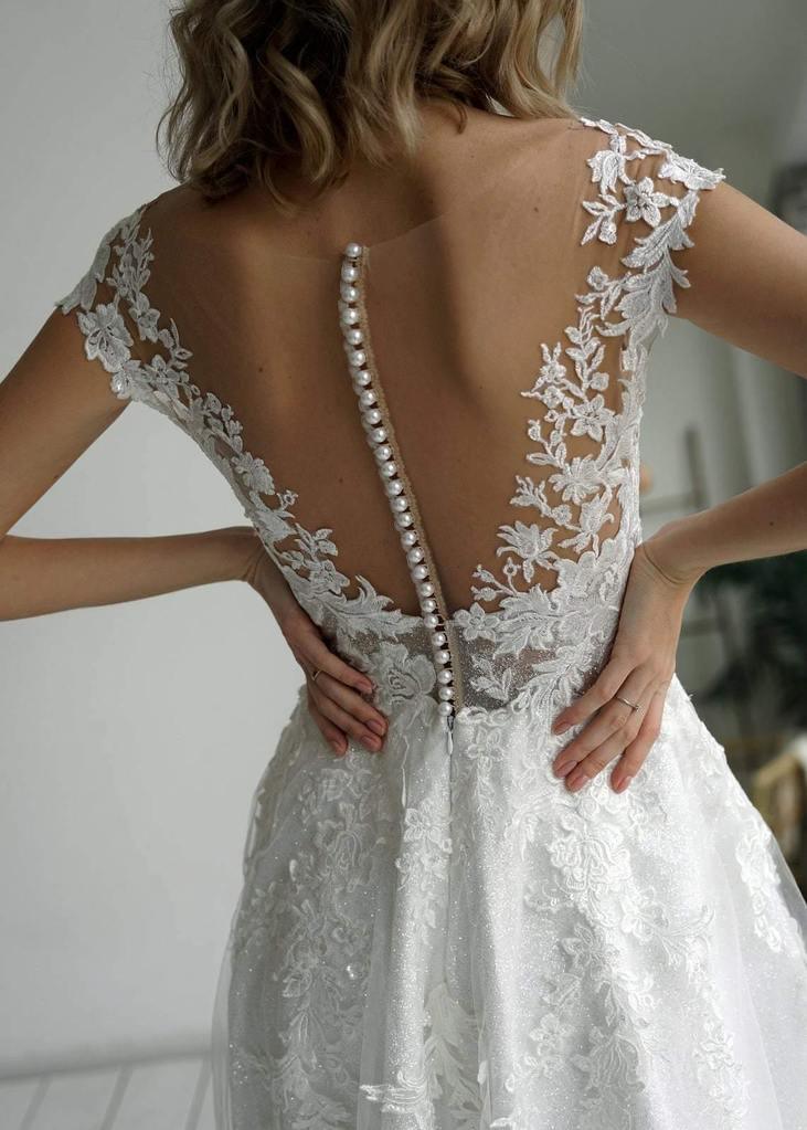 Close-up of the glitter fabric and applique details on the wedding dress.