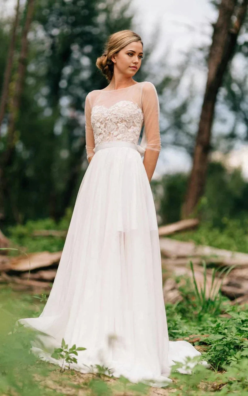 Full view of an elegant A-line sweetheart long sleeve wedding gown with illusion lace details.