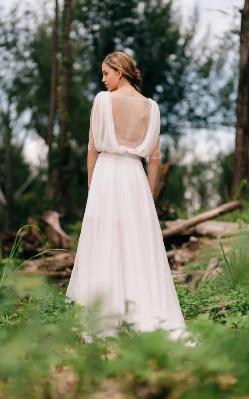 Close-up of the intricate lace details on the bodice and illusion long sleeves of the wedding dress.