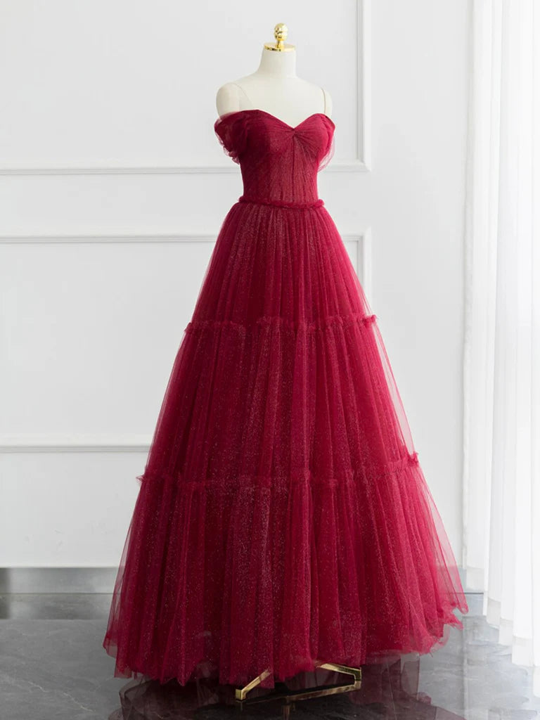 Woman wearing a long burgundy A-line prom dress with a sweetheart neckline.
