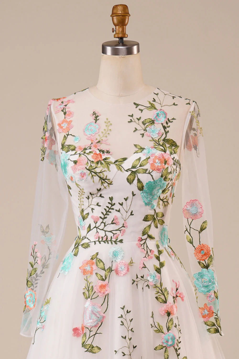 Close-up of the intricate floral embroidery on an ivory tulle wedding dress.