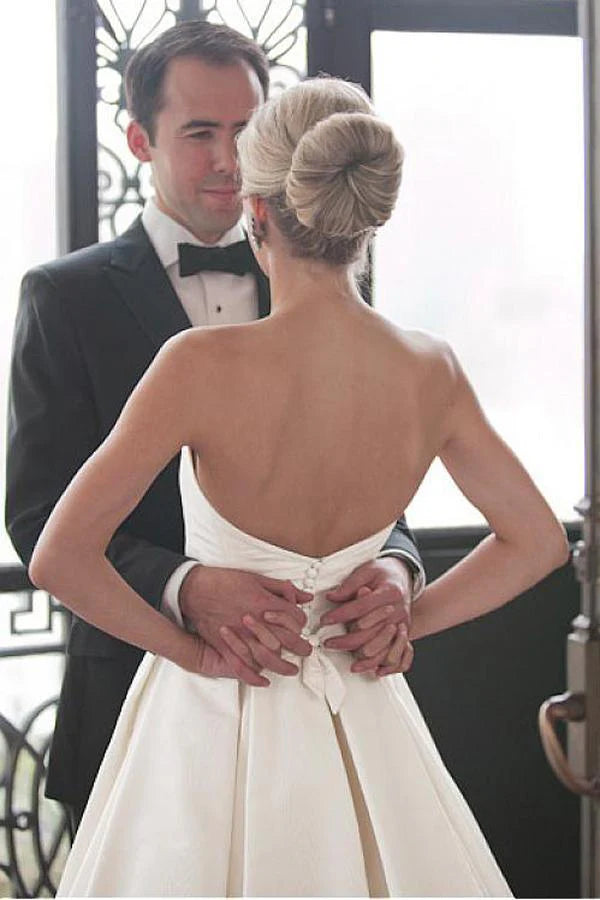 Close-up of ruched detail on the bodice of an ivory sweetheart wedding gown.