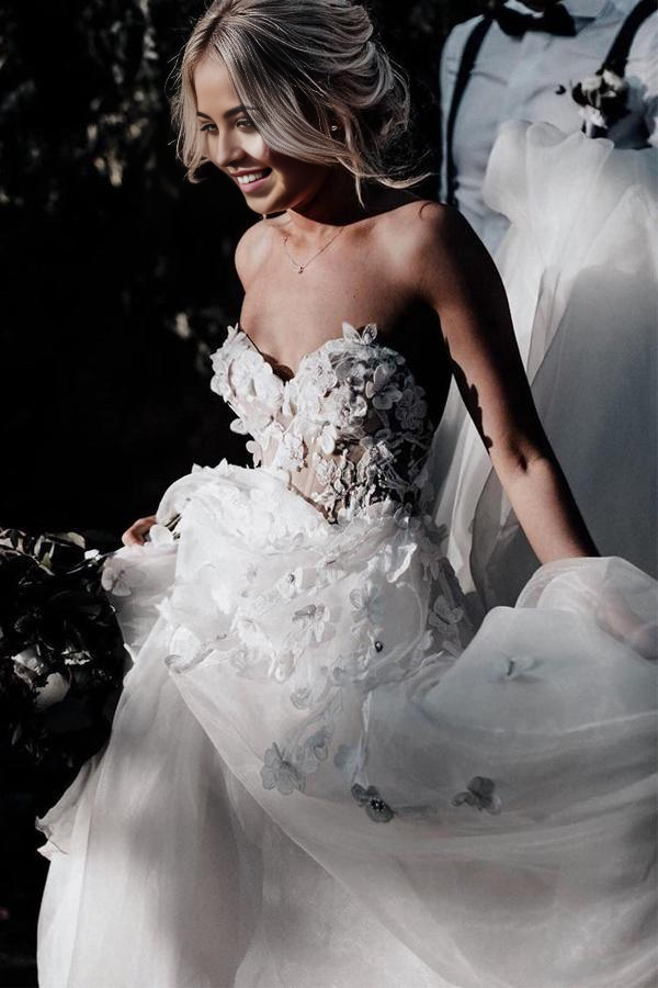 Side profile of the A-line sweetheart wedding dress with delicate appliques.