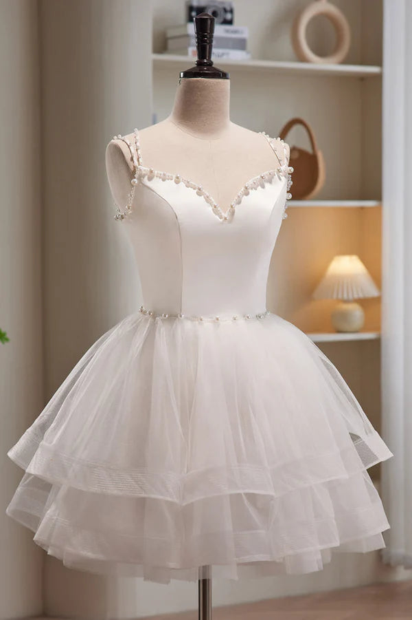 Elegant A-line tulle homecoming dress with sweetheart neckline and spaghetti straps, front view in blush pink.