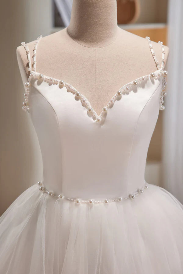 Side profile of an A-line short homecoming dress in blush pink tulle fabric.