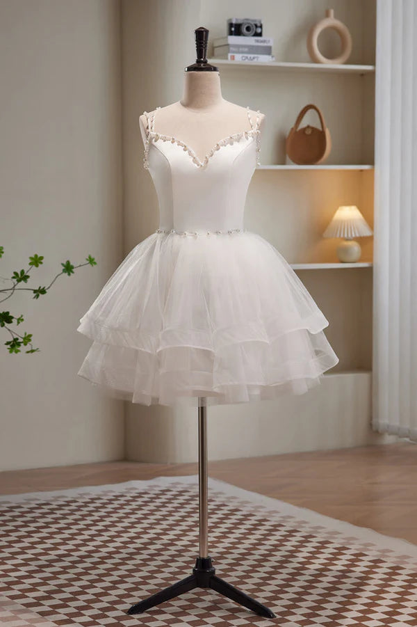 Close-up of the sweetheart neckline and spaghetti straps on a blush pink tulle dress.