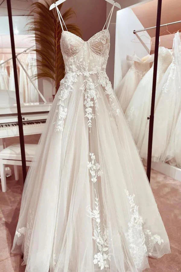 Front view of an A-line sweetheart tulle wedding dress with spaghetti straps and appliques.
