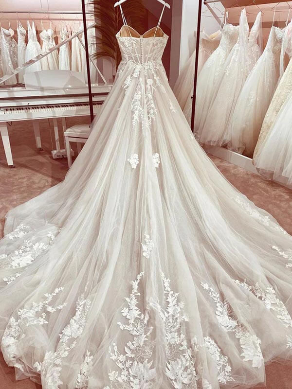 Full length view of a romantic A-line wedding gown in tulle with intricate appliques.