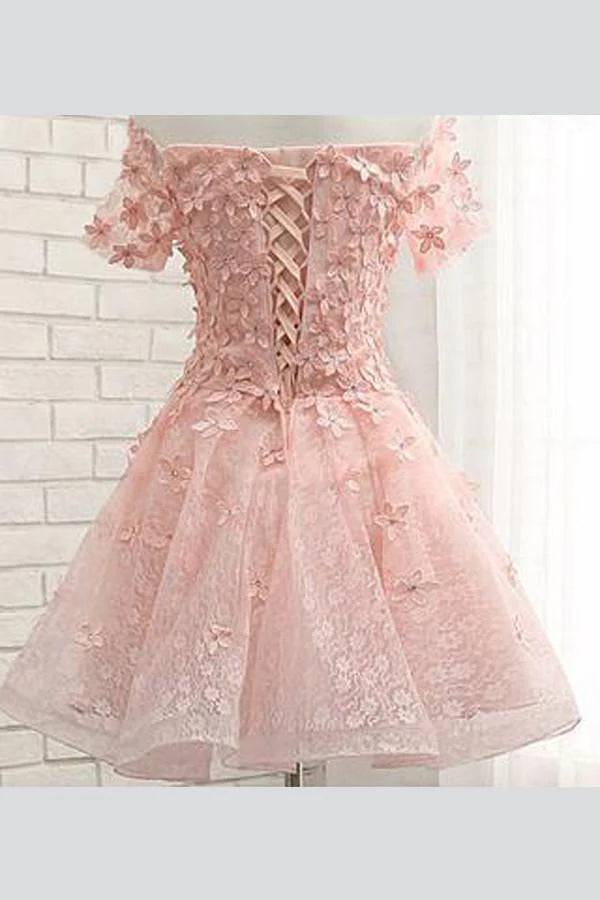 Detail view of the floral appliques and tulle fabric on the off-shoulder dress.