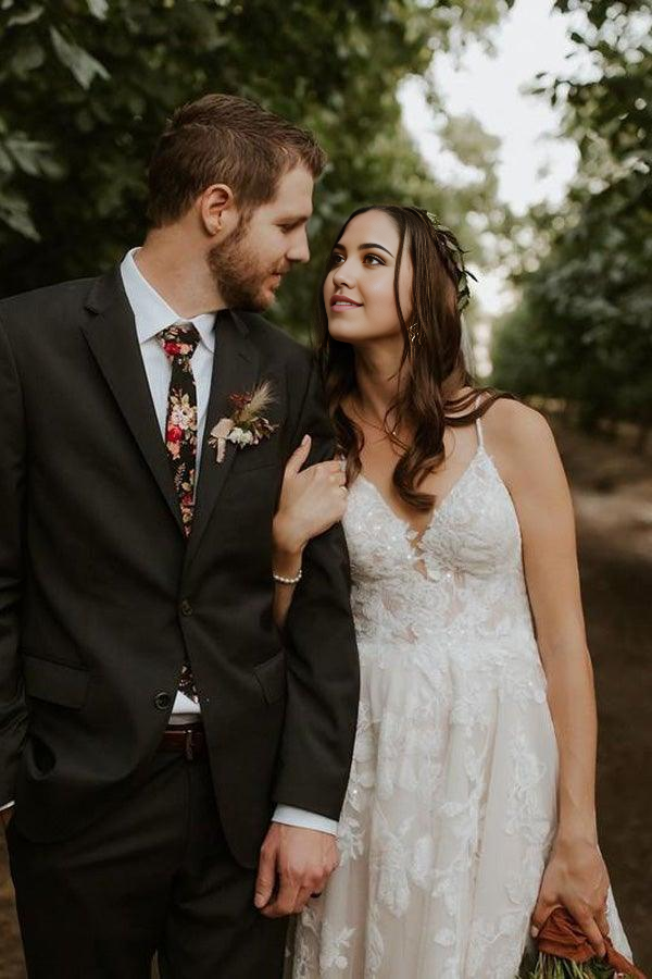 Close-up of the appliqued straps and V-neckline on an A-line wedding dress.