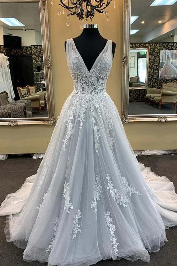 Model wearing an elegant A-line V-neck wedding gown with delicate appliques and a sweep train.