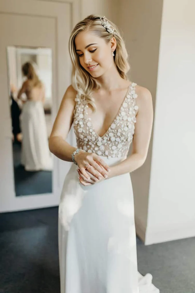Elegant A-line V-neck wedding dress with illusion train on a beach.