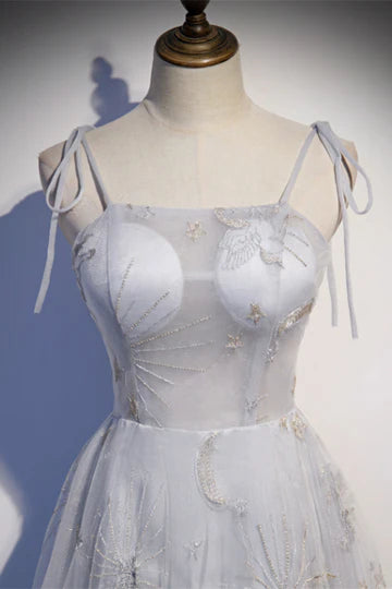 Woman wearing a long A-line V-neck formal dress with embroidered details.
