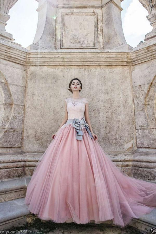 Pink A-line tulle wedding dress with cap sleeves, lace details, and a bowknot.