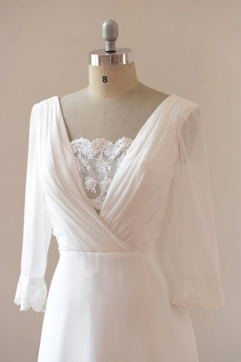 Side view of a flowing A-line chiffon wedding dress with delicate sleeves.