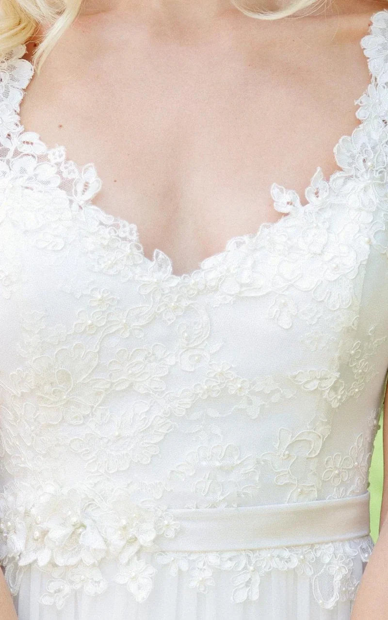 Bride wearing an A-line V-neck chiffon lace wedding gown, side profile.
