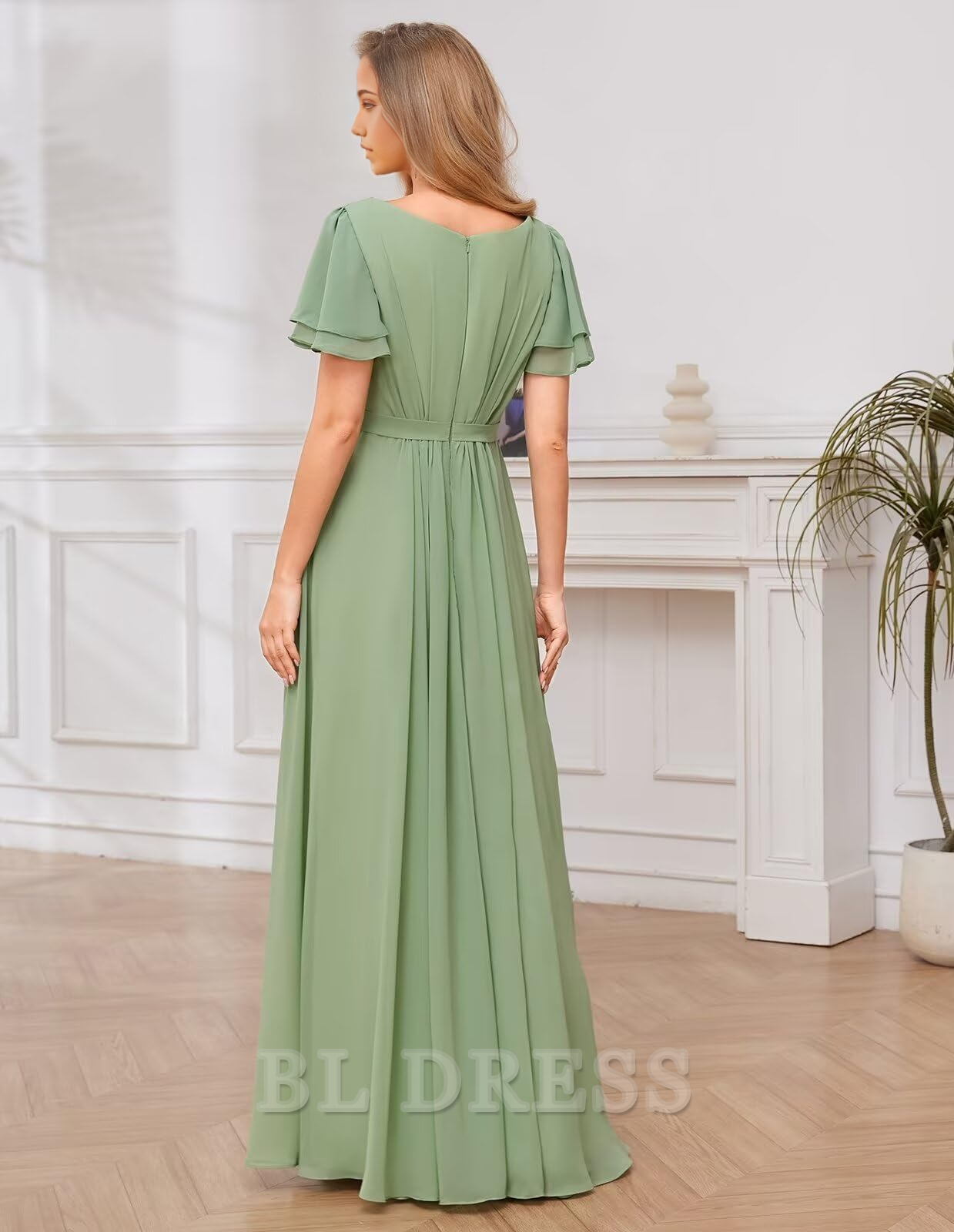 Woman posing in a long A-line V-neck formal dress with flowing chiffon sleeves.