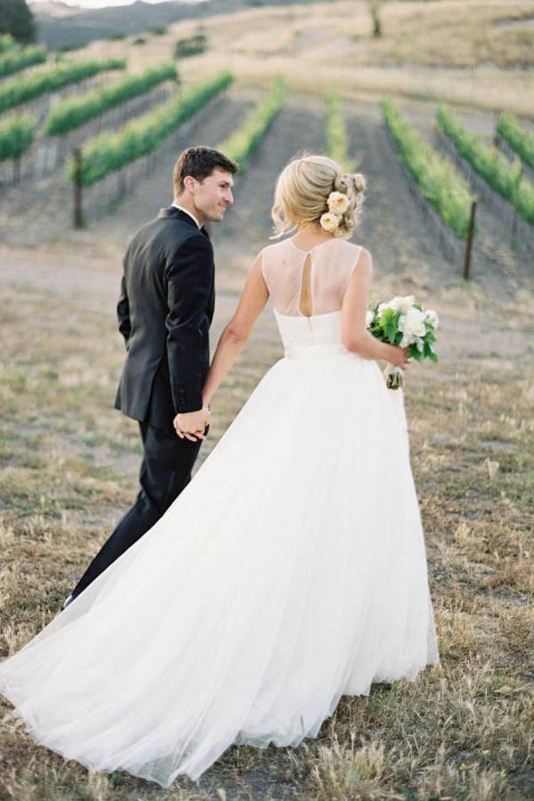 Full length view of an A-line illusion tulle vintage outdoor ivory wedding dress.
