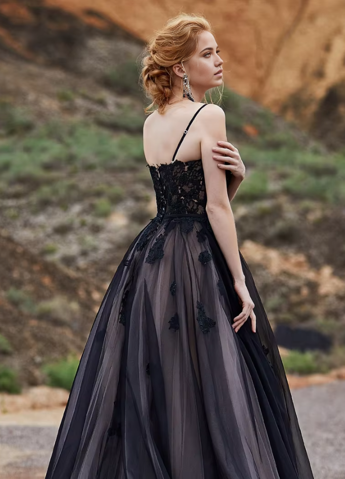 Close-up of lace applique on a black A-line wedding dress.