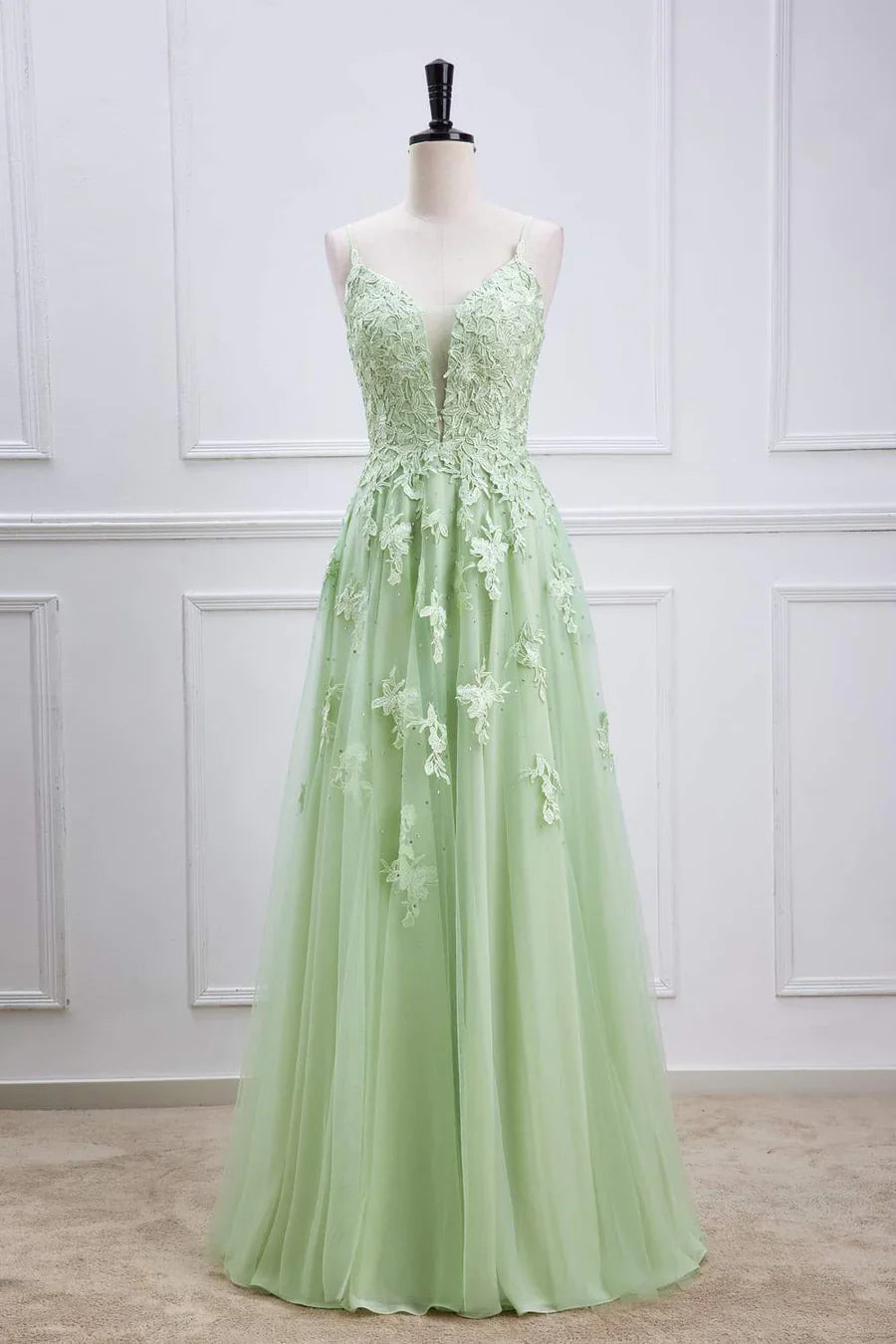 Sage green A-line prom dress with lace appliques and V-neckline.