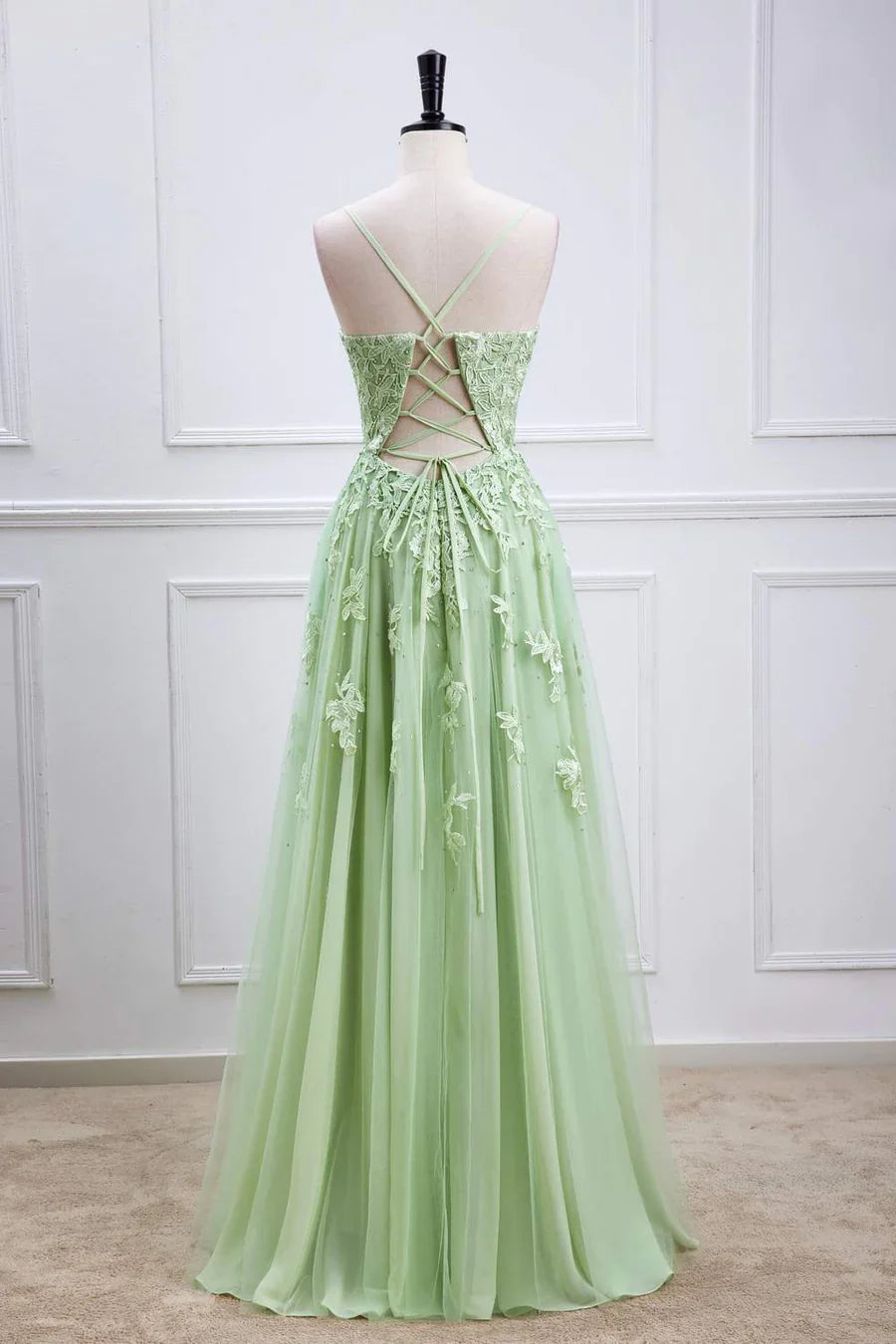 Back view of sage green prom dress showing lace-up detail.