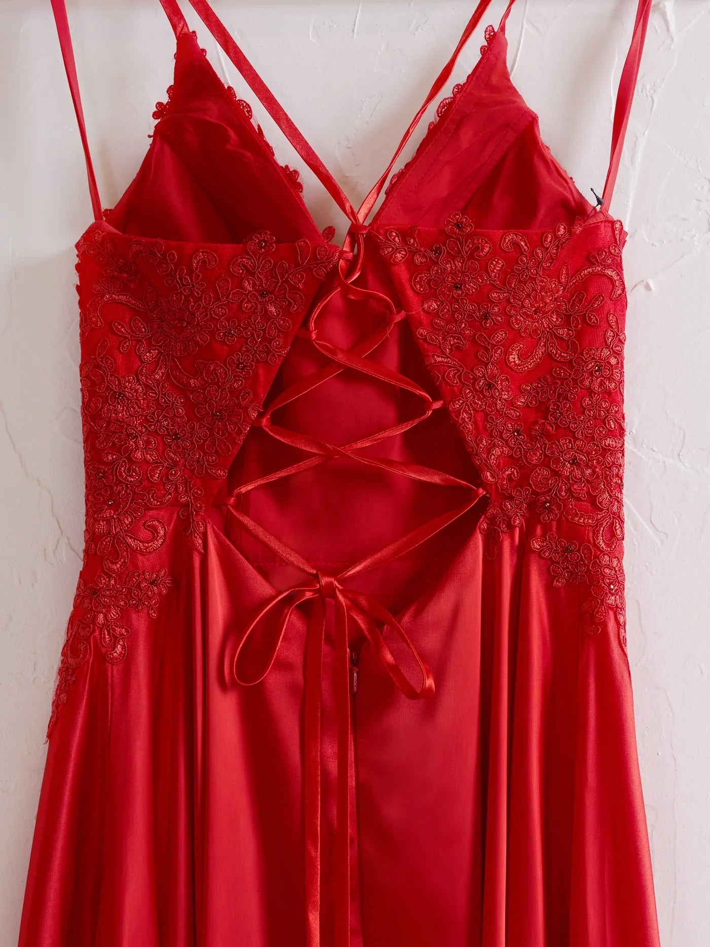 Close-up of lace applique on red A-line dress.