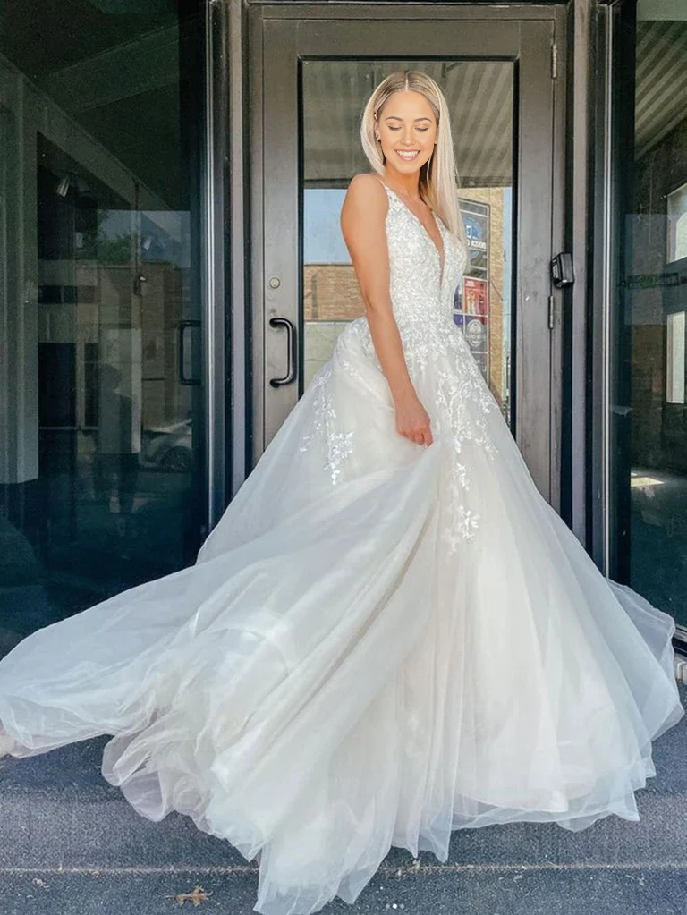 Elegant A-line V-neck ivory lace wedding dress with a long train.