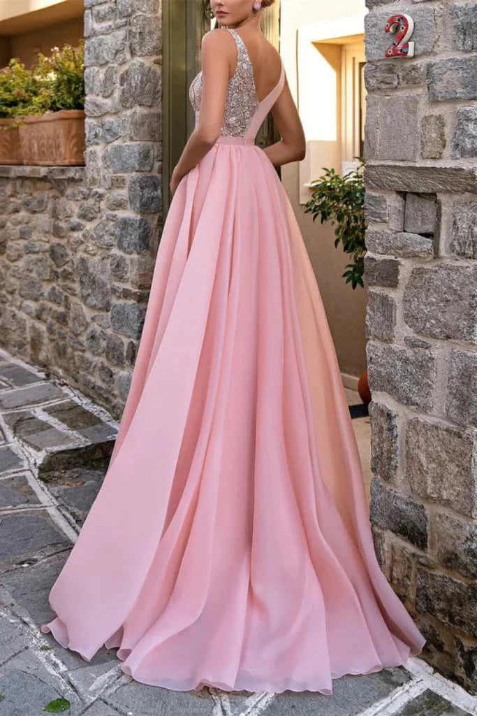 Woman posing in a long V-neck lace formal gown.