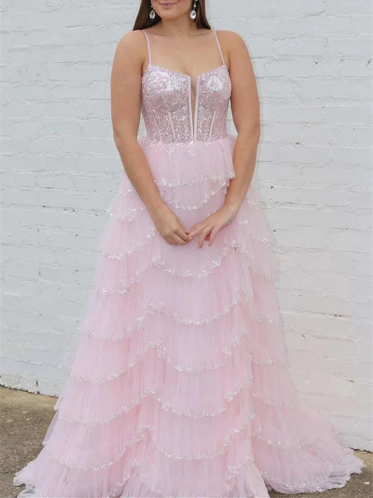 Woman wearing an elegant A-line lace prom dress with spaghetti straps.