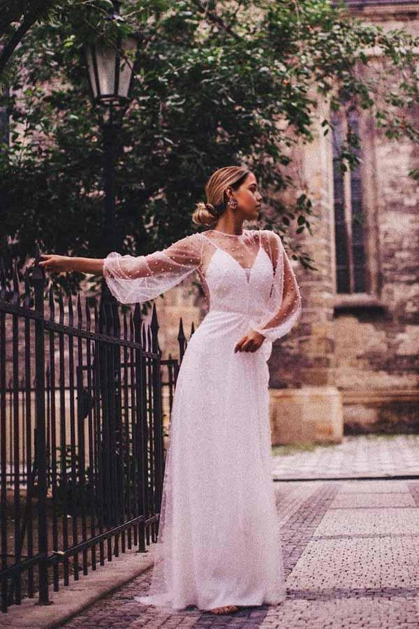 Elegant A-line V-neck long sleeve wedding dress with tulle and pearl details.