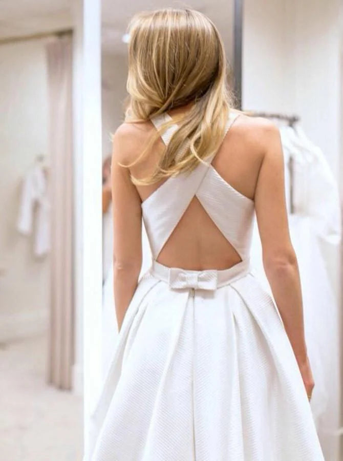 A-line bridal gown featuring an open back, criss-cross straps, and pockets.