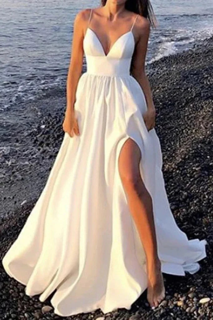 Model wearing a white A-line V-neck formal dress with an open back and high slit.