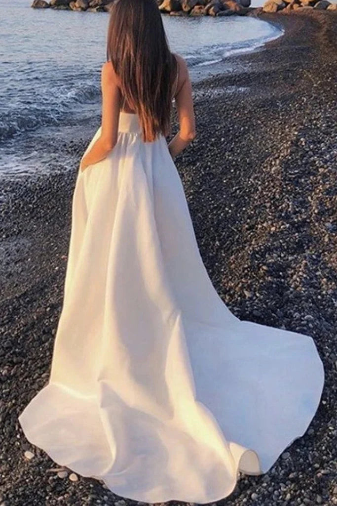 Back view of a white A-line V-neck formal dress featuring an open back and high slit.