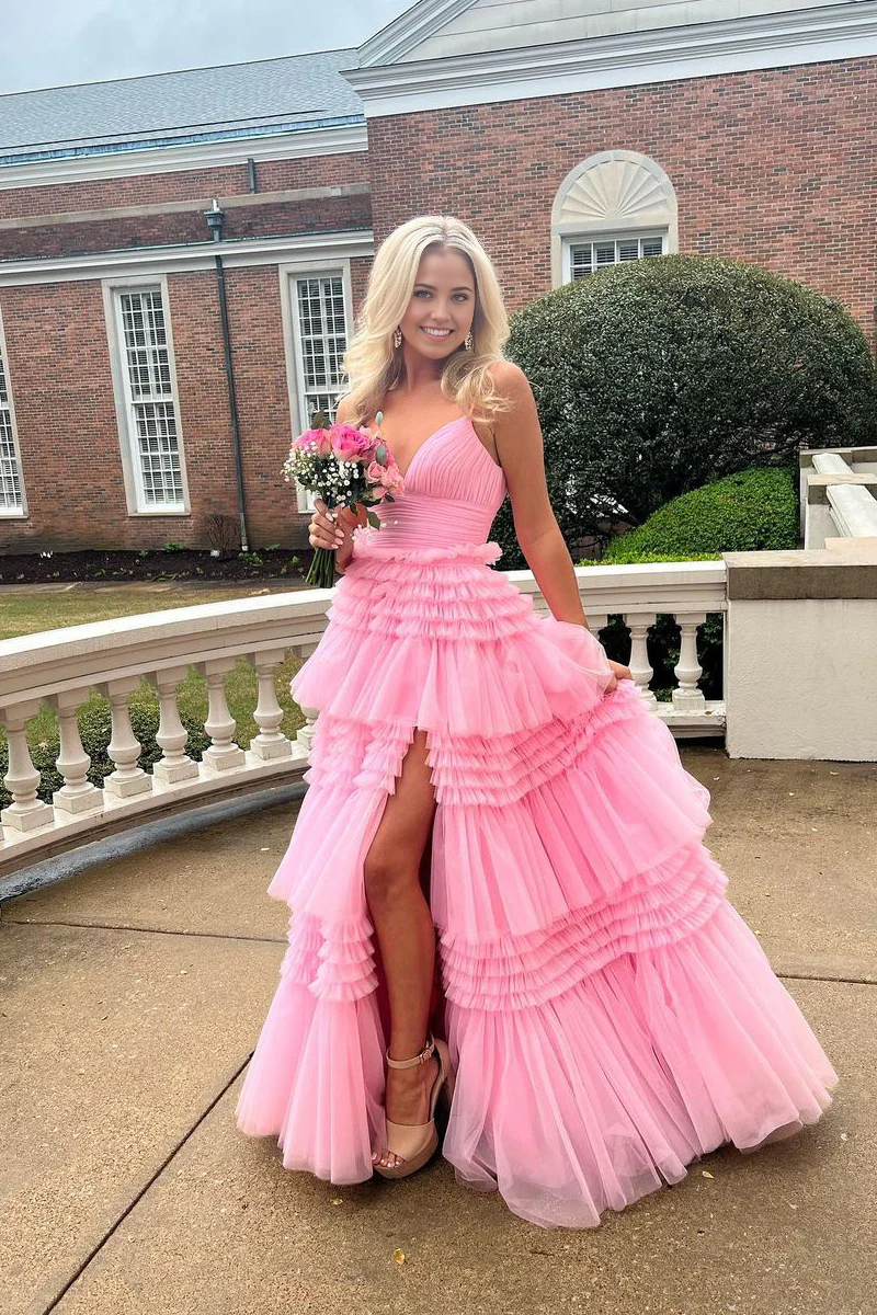 Model wearing a pink A-line V-neck tulle prom dress with a high slit.