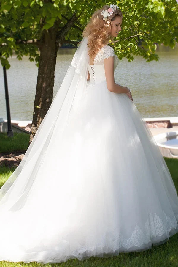 Side profile of the A-line wedding dress, highlighting the ruched bodice and cap sleeves.