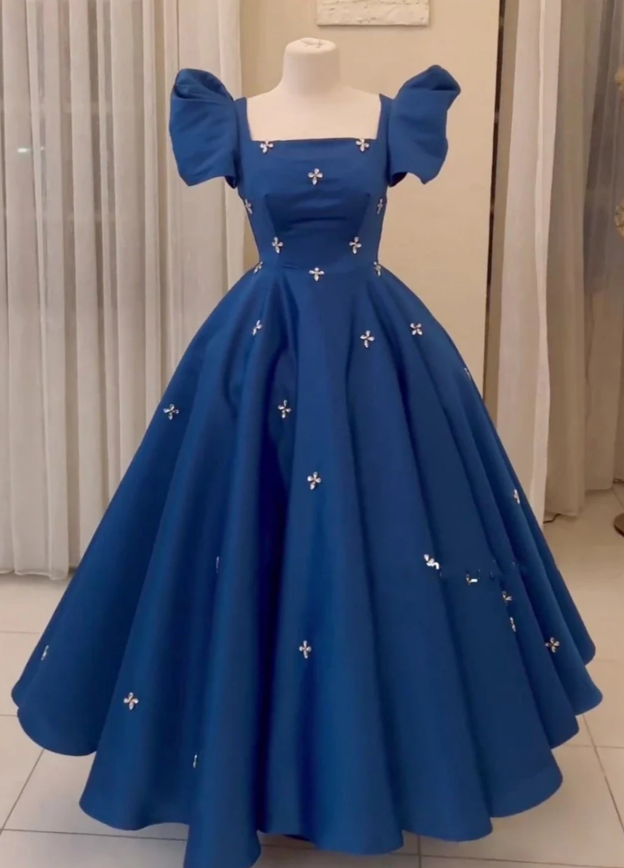 Model wearing an elegant A-line V-neck satin ball gown in a formal setting.