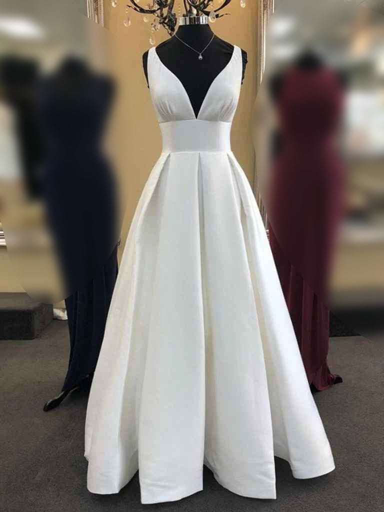 Woman wearing a dark blue A-line V-neck satin long prom dress.