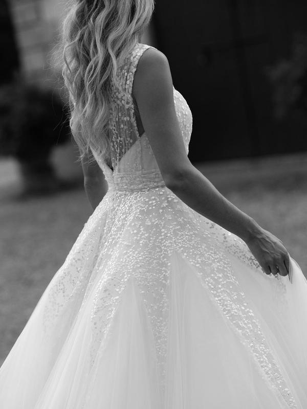 Close-up of the V-neckline with intricate sequin and lace embellishments on the wedding dress.
