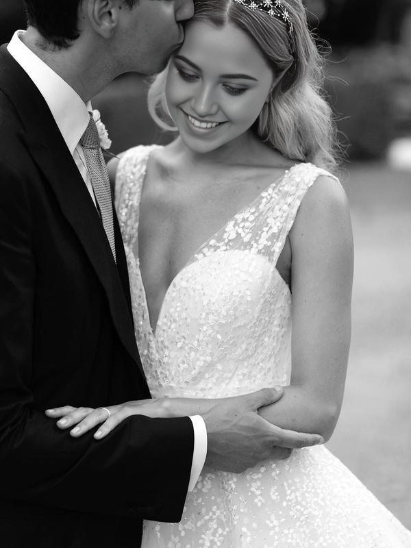 Detailed view of the delicate lace and sparkling sequin patterns on the wedding dress bodice.