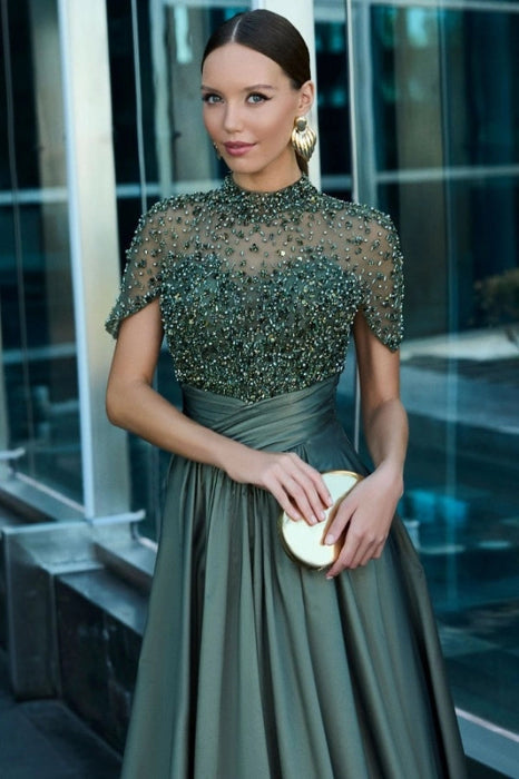 Close-up of the beaded short sleeve on the dark green satin dress.