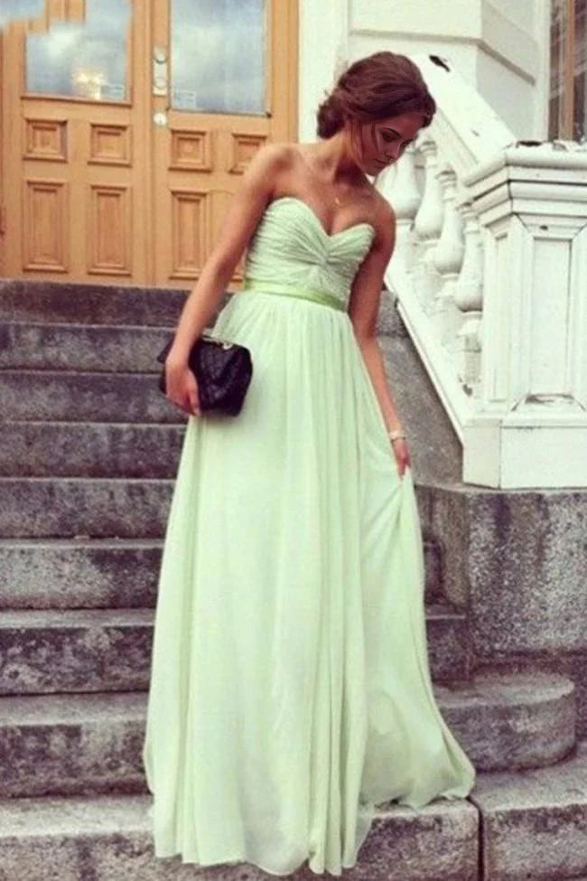 Back view of a woman in a flowing A-line V-neck evening gown.